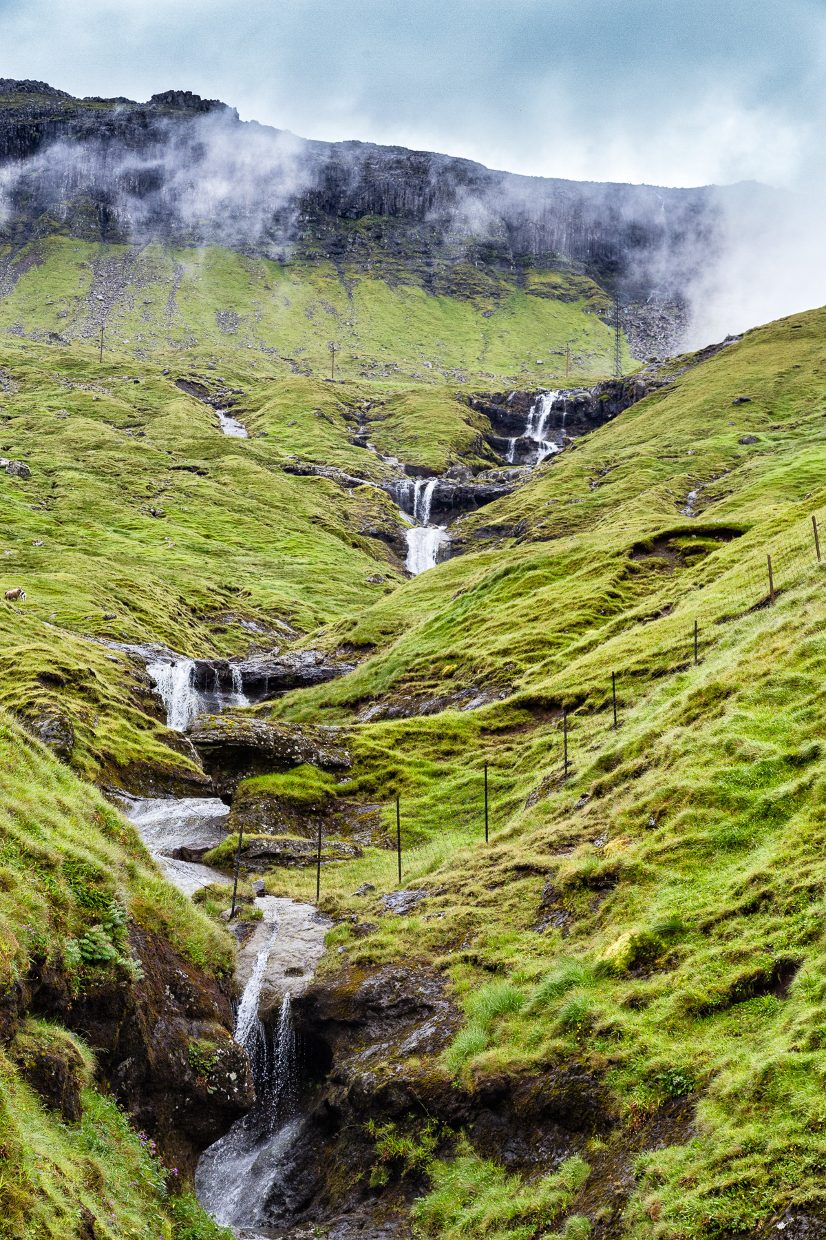 Waterfall is right before the tunnel near Kaldbaksbotnur, Faroe Islands by Jon Armstrong for Blurbomat.com.